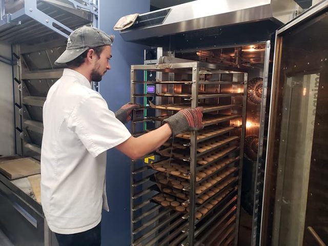 Pâtissier enfournant des biscuits